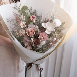 A sweet handheld bouquet featuring blush-toned flowers and dried wheat